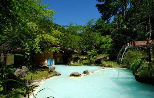 松本泡汤旅馆的一片蓝水,有岩石和树木