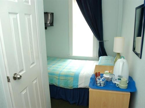福克斯通肯特米尔旅馆的一间卧室配有一张床和一张带蓝色台面的桌子