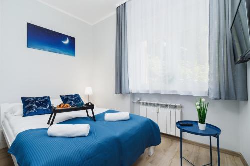 克拉科夫Apartment Smoluchowskiego Cracow by Renters的一间卧室设有两张蓝色的床和窗户