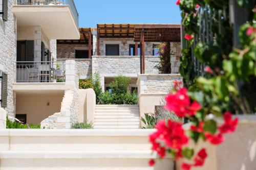 伊西翁Margo Beach Hotel的享有带楼梯和红色鲜花的建筑景致