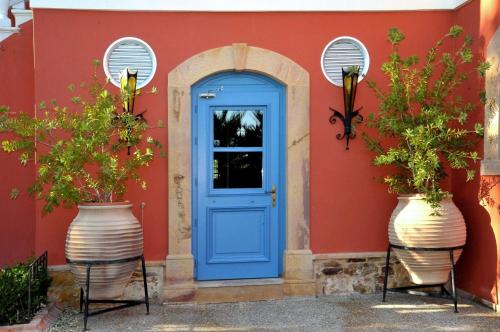 坎博斯Sourediko的红色房子上一扇蓝色门,两只大花瓶