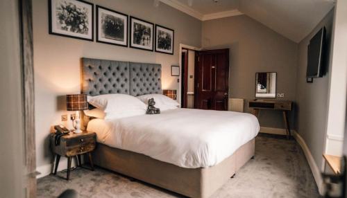 柯克沃尔柯克沃尔酒店的卧室配有一张白色大床,墙上挂着一些图片