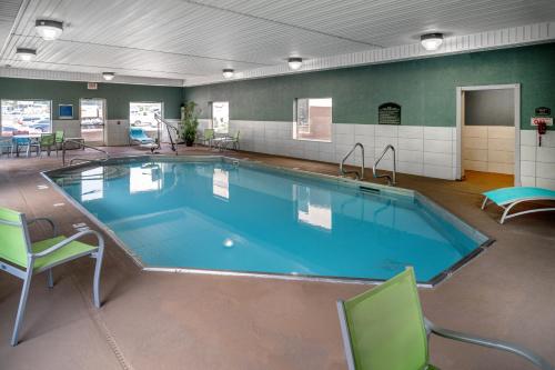 派克维尔派克维尔智选假日套房酒店的一个带椅子和桌子的大型游泳池