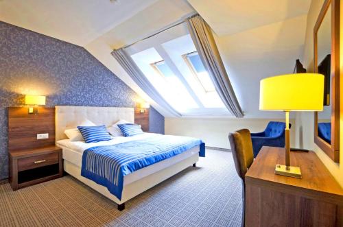 凯蒂赖贝西Tristan Hotel & SPA的一间卧室配有一张床、一张书桌和一个窗户。