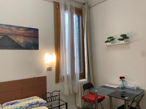 威尼斯阿尔奇的旅馆的一间卧室配有一张床、一张桌子和一个窗户。