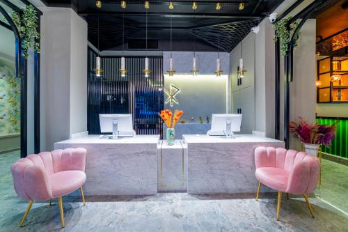 阿拉尼亚Aria Riva Apart Hotel的一个带2把粉红色椅子和柜台的沙龙