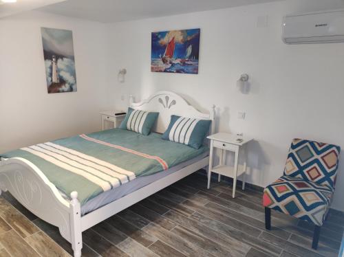 茹里洛夫卡Pensiune Blue Coral Jurilovca的一间小卧室,配有一张床和一把椅子