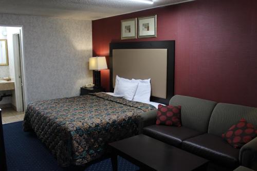 加洛韦大西洋城经济旅馆和套房的酒店客房,配有床和沙发
