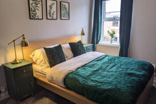 莫珀斯Duck & Heron Cottage的一间卧室配有一张带绿毯的床和窗户。
