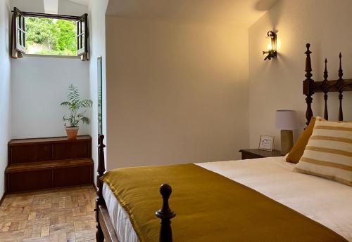 奥比多斯Pátio da Muralha的一间卧室设有一张床和一个窗口