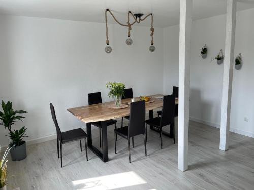 马克莱贝格NEU Auszeit in moderner Wohnung in Seen-Nähe的一间带木桌和椅子的用餐室