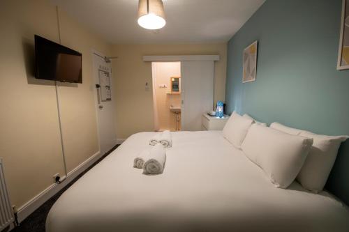 欧文Irvine Riverside Guesthouse by Paymán Club的卧室配有白色的床和毛巾