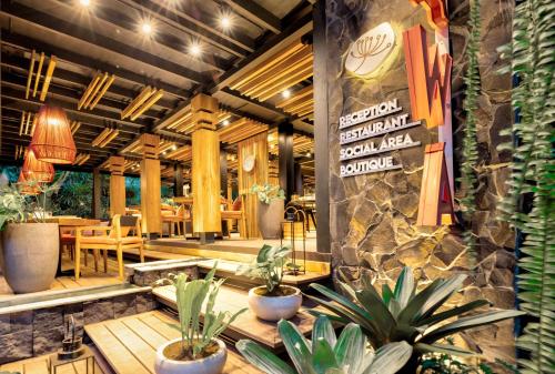 别霍港aWà Beach Hotel的一间餐厅,房间里摆放着桌子和盆栽植物