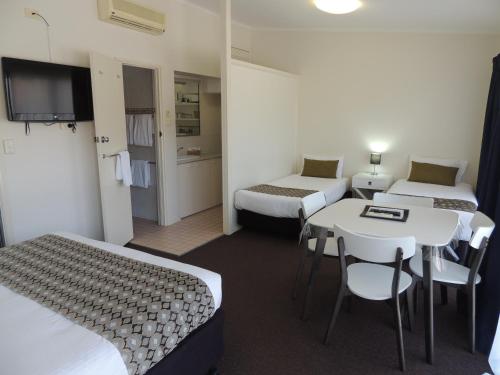 科夫斯港普瑞米尔康福特茵酒店的酒店客房带两张床和一张桌子以及椅子。