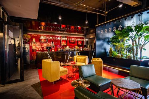 西安合宿设计师酒店的一间酒吧,配有黄色和红色的椅子和柜台