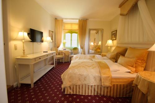 布罗斯特科克达尔斯洛茨酒店 的一间卧室配有一张床、一张书桌和一面镜子