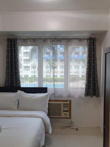 马尼拉Vangie's Place at SEA RESIDENCES的一间卧室设有两张床和窗户。
