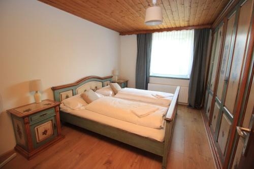 迈斯霍芬Edelweiss Apartment的一间卧室设有一张大床和一个窗户。