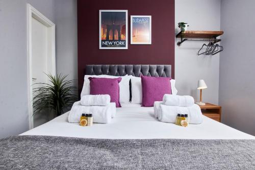 达宁顿堡Delven House, Apartment 4的卧室配有一张带紫色枕头的大型白色床。