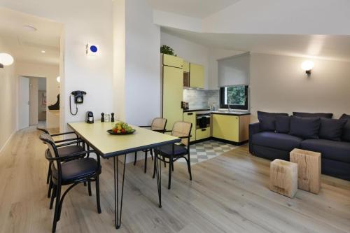 夏蒙尼-勃朗峰Appart'hôtel Bellamy Chamonix的客厅以及带桌子和沙发的厨房。