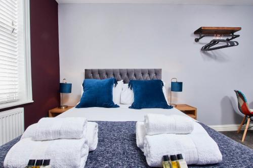 达宁顿堡Delven House, Apartment 5的一间卧室配有一张带蓝色枕头的大床