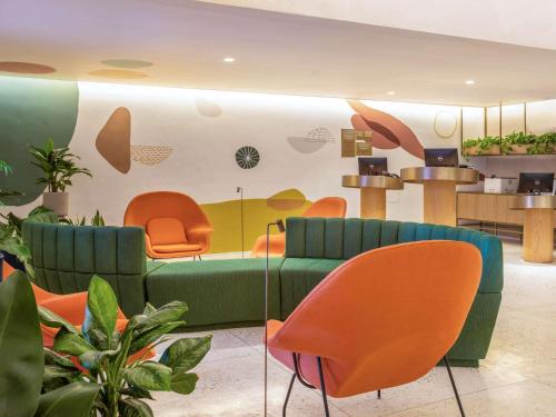 里约热内卢Mercure Rio Boutique Hotel Copacabana的一间等候室,配有绿色家具和橙色椅子