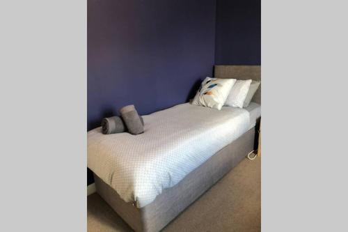 提普顿Dudley House **Staycation & Contractors** Sleeps 7的一间卧室配有带白色床单和枕头的床。
