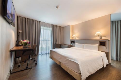布加勒斯特Hotel CH Bucharest的酒店客房设有一张大床和一张书桌。