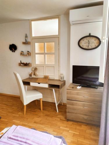 瓦尔纳Apartament Bogoslovovi的客厅配有书桌和墙上的时钟