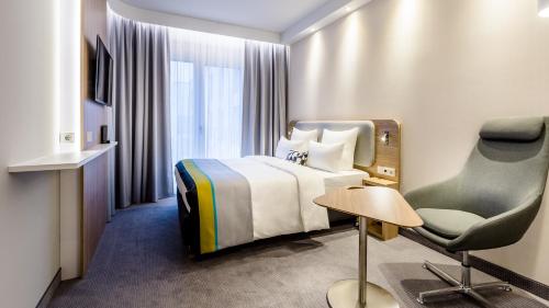 罗森海姆Holiday Inn Express - Rosenheim, an IHG Hotel的配有一张床和一把椅子的酒店客房