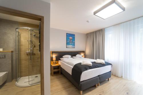 斯维诺乌伊希切Villa Aura的酒店客房配有一张床和淋浴