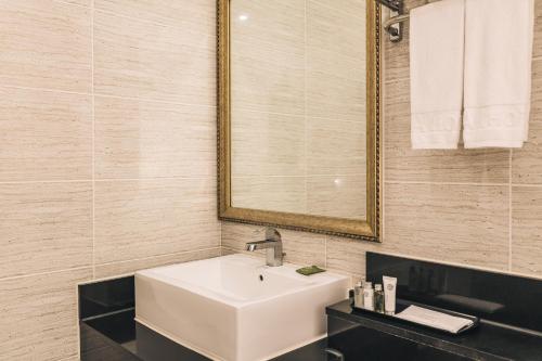 西归浦市迈吉星酒店的浴室设有白色水槽和镜子