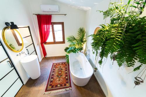 萨波夫拉Flor de Mandarina的浴室设有白色的浴缸和植物
