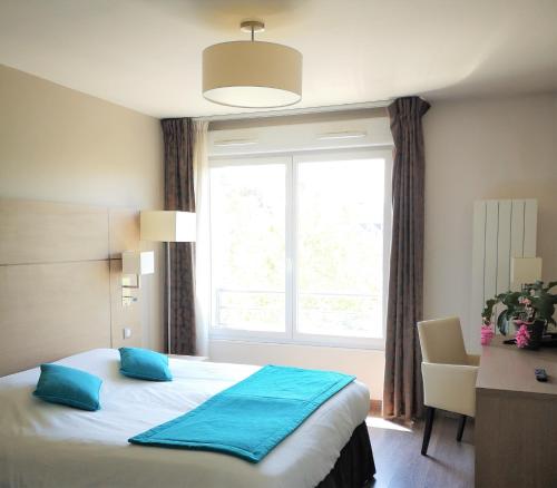 瓦朗西纳剧院家庭公寓酒店的一间卧室配有一张带窗户的床和一张书桌