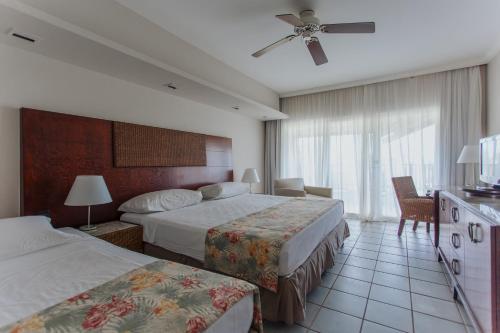 科斯塔萨乌佩Sauipe Resorts Ala Terra - All Inclusive的酒店客房配有两张床和吊扇。