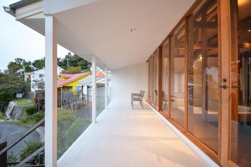 淡路Wellis Villa HANARE的房屋的内部走廊,设有玻璃门和阳台