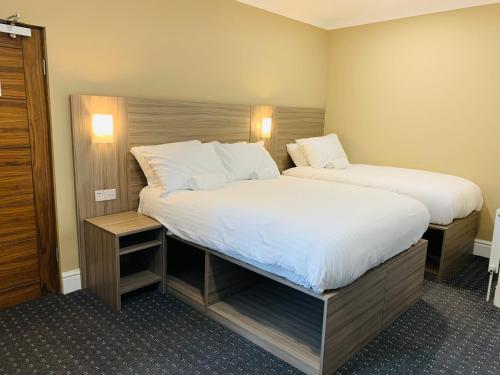 雷迪奇De Regency Style Hotel的一间卧室配有两张带白色床单的床