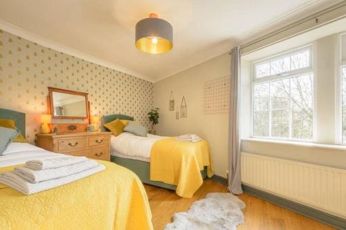 哈利法克斯Entire cottage in the beautiful Calder Valley的一间卧室设有两张床和窗户。