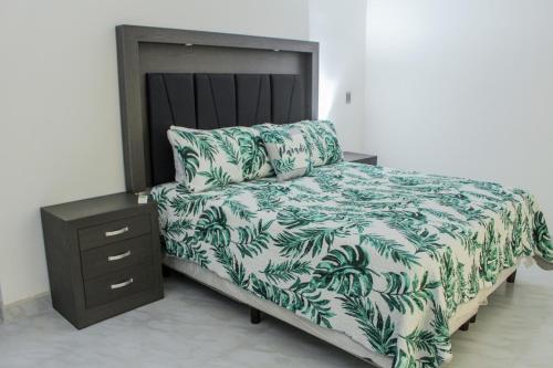 佩尼亚斯科港VILLA COSTA FELIX 1的一张带绿白色毯子和床头柜的床