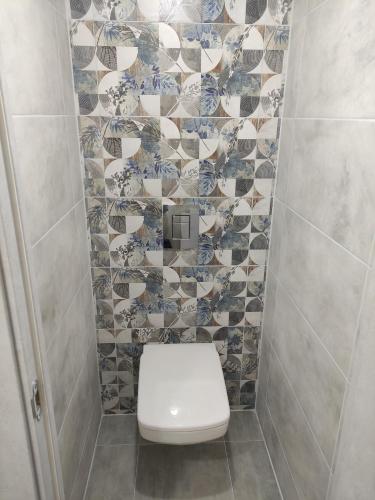 蒂拉斯波尔Victoria的一间带卫生间和瓷砖墙的浴室