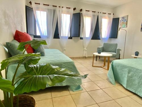 塞博河畔卡莱塔Maresia Holiday House的客房设有两张床、椅子和窗户。