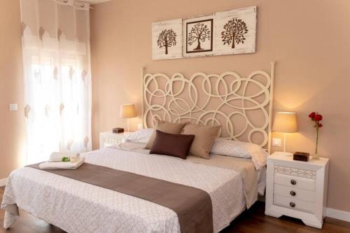圣马丁德拉韦加La Casa de Silvia Visita Parque Warner, Madrid y alrededores的一间卧室配有一张带白色床罩的大床