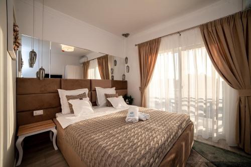 旧瓦马Club Waves - Vama Veche的一间卧室设有一张大床和一个大窗户