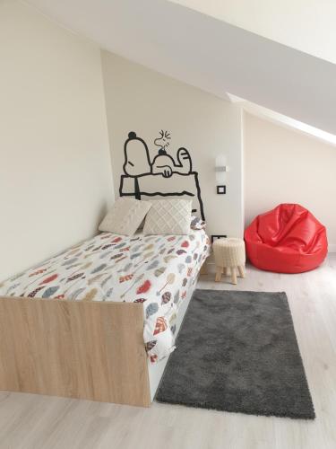 乌迪亚莱斯堡Casa La Quintana的一间卧室配有一张床和一个红色的搁脚凳