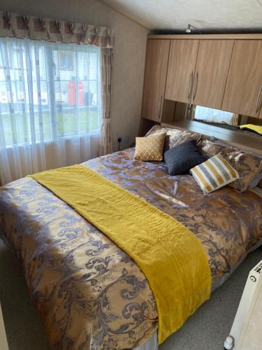 米勒姆Port Haverigg Millom的一间卧室配有一张带黄色毯子的大床
