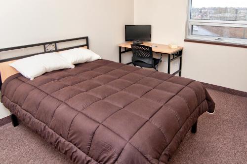 北湾北湾会议中心公寓的一间卧室配有一张床和一张带电脑的书桌
