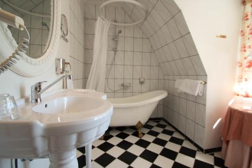 霍恩拜克桑特哈斯城堡酒店的白色的浴室设有浴缸和水槽。