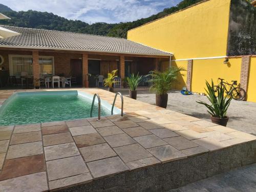 卡拉瓜塔图巴Tudo de Bom的房屋前的游泳池