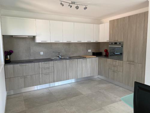RiazzinoModern Living的厨房配有白色橱柜和不锈钢用具