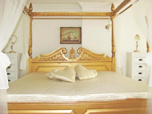 梅明根斯多辰法尔布公寓的一间卧室配有一张带两个枕头的木制天蓬床